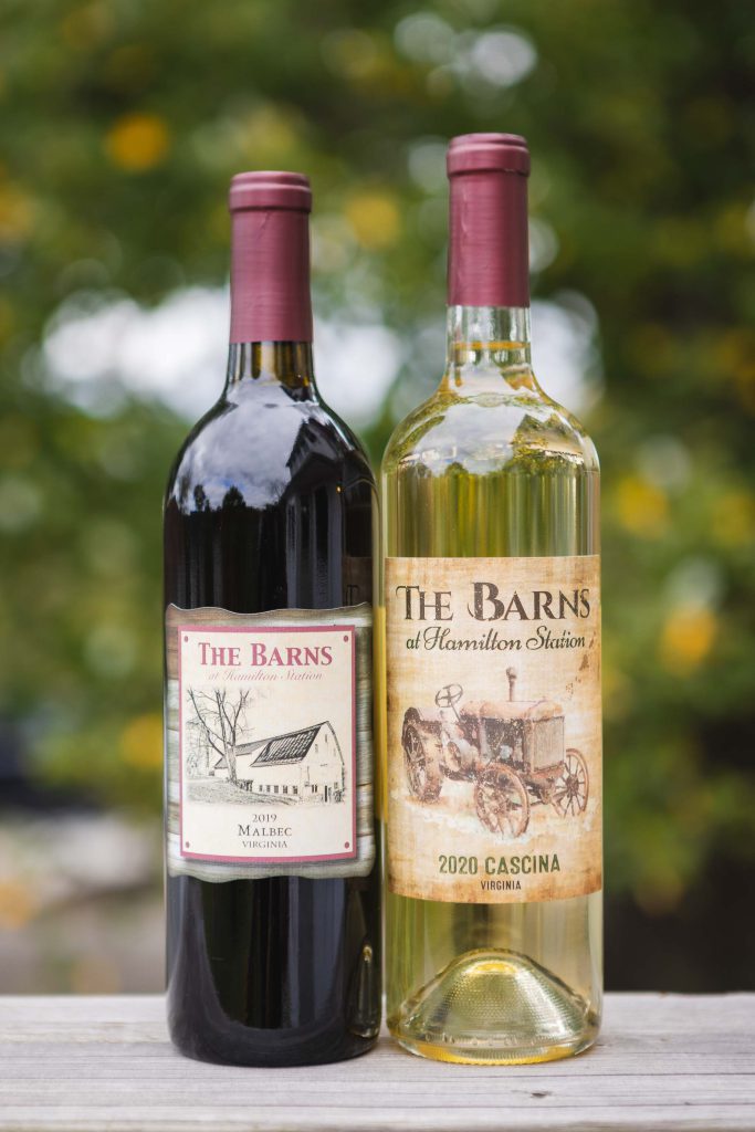 Detailed display of two bottles of wine on a wooden table at a wedding.