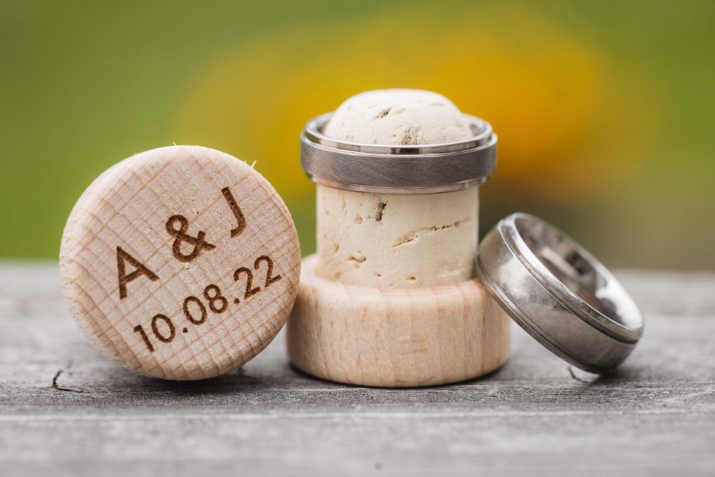A wedding ring intricately placed on a wooden wine cork.