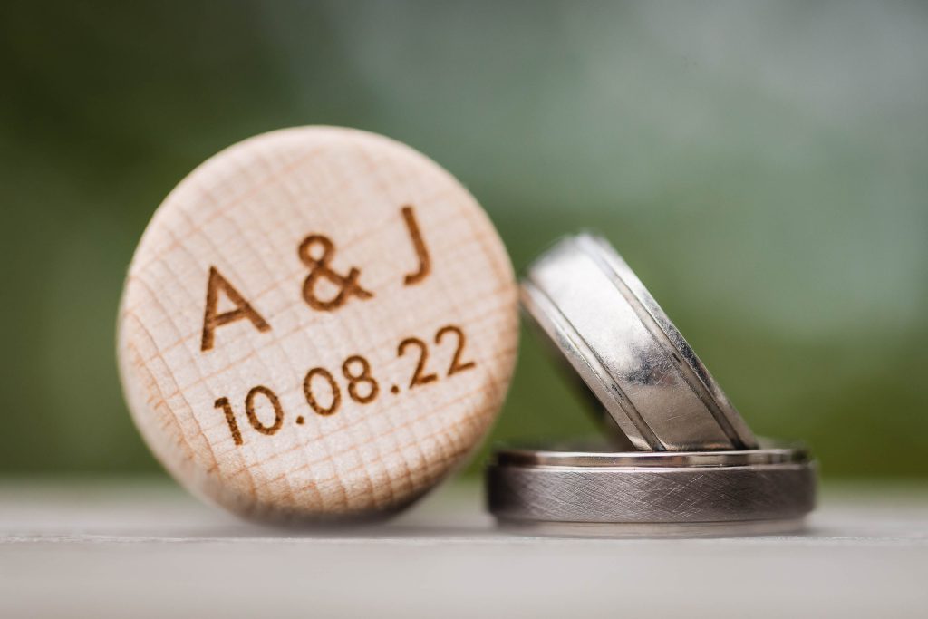 A handmade wooden wedding ring with personalized details.