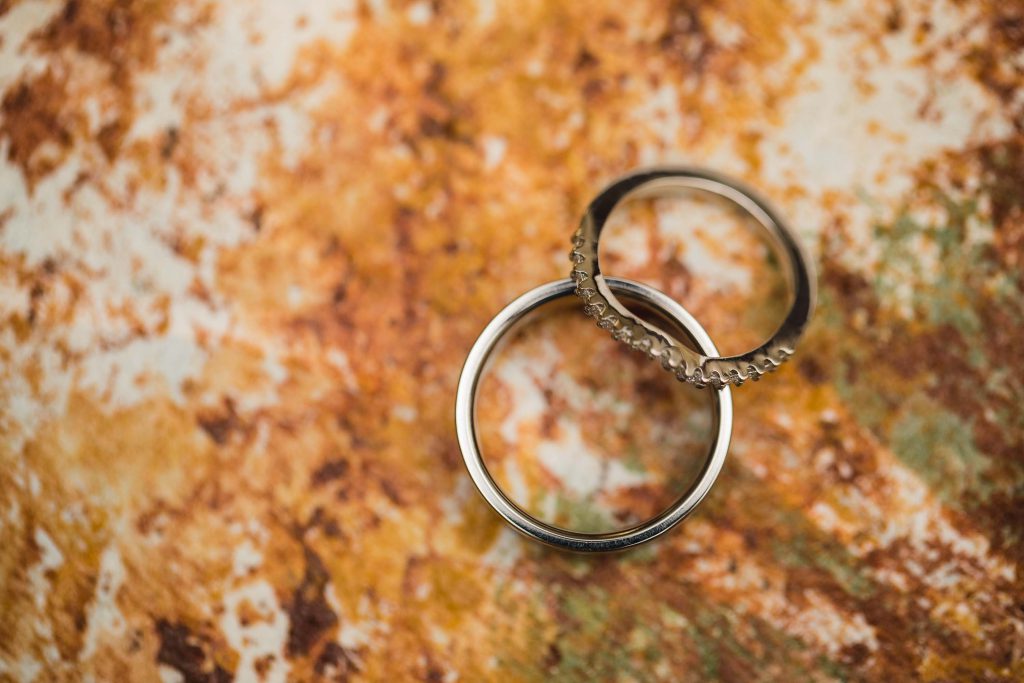 Detailed wedding rings resting on an orange background.
