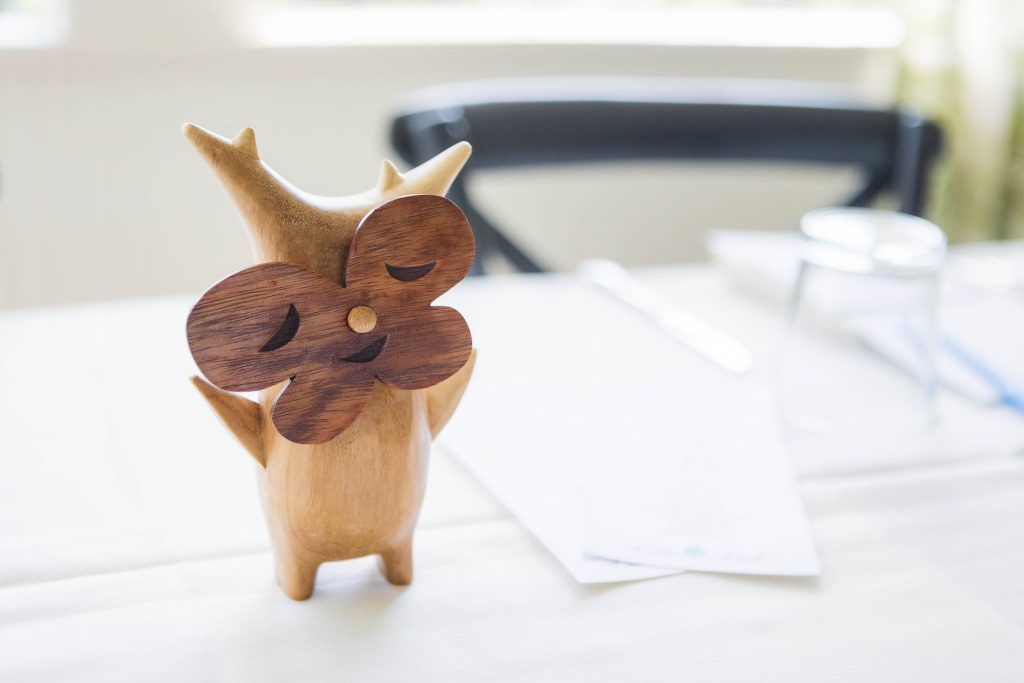 A wooden owl adding wedding details to a table.