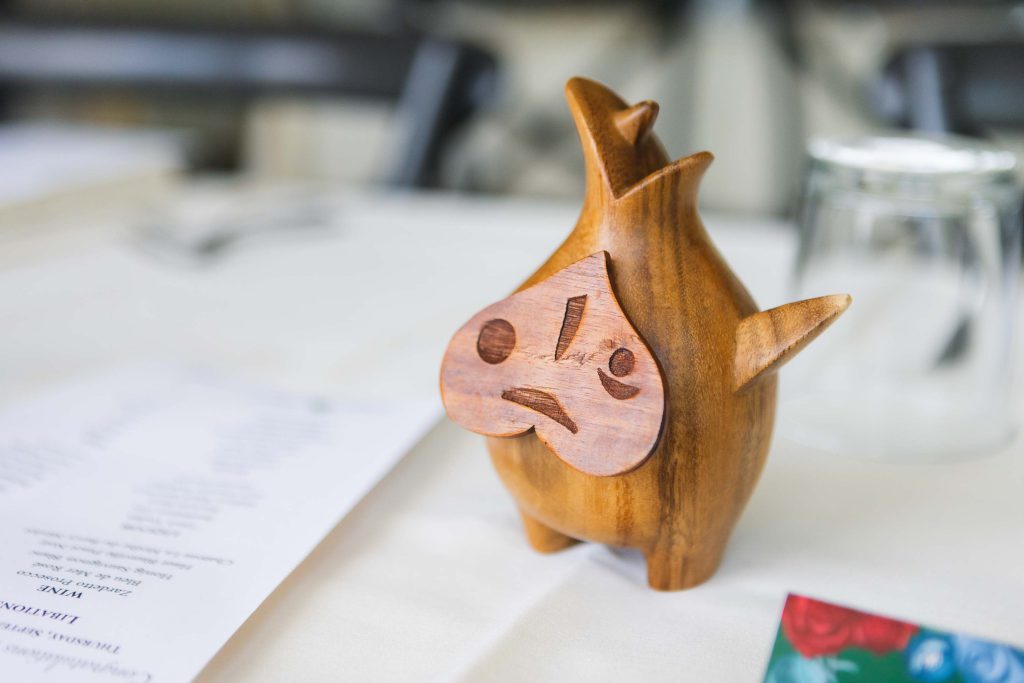 A wooden statue of a fish sitting on a table, perfect for wedding decorations.