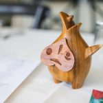 A wooden statue of a fish sitting on a table, perfect for wedding decorations.