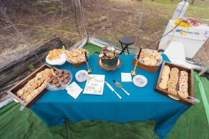 A blue tablecloth on a table in a tent at a wedding.
