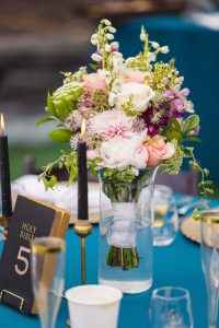 A clear vase with flowers in it, perfect for wedding details.