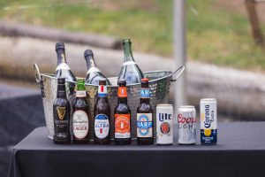 A detailed table centerpiece at a wedding filled with beer bottles.