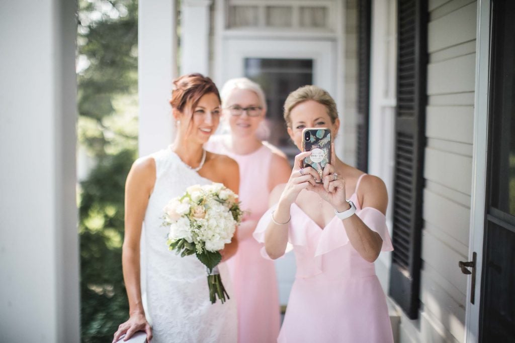 Bridesmaids posing for a wedding portrait on the porch.
