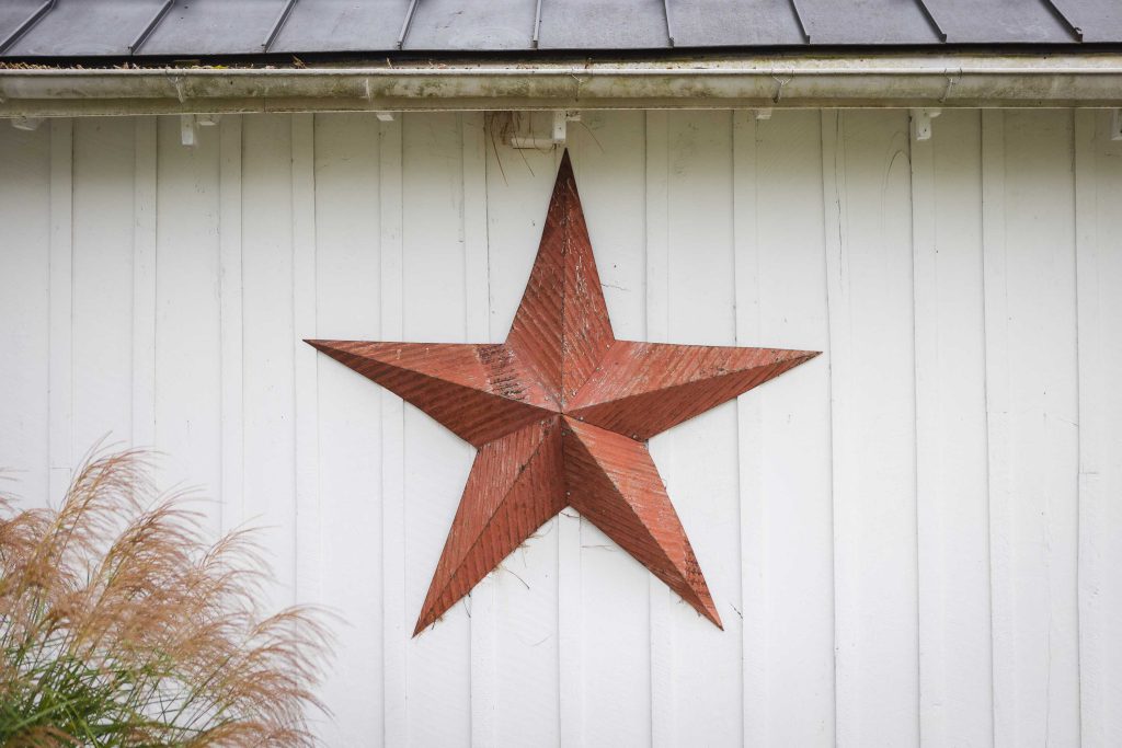 A metal star hanging on the side of a building with intricate details.