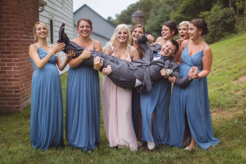 A group of bridesmaids and groomsmen posing for a wedding portrait.
