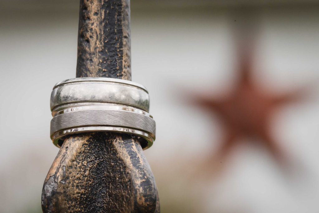 A detailed wedding ring resting on a wooden pole.