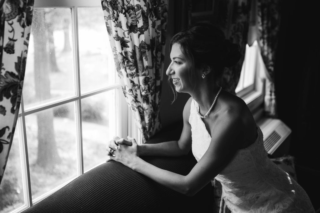 A candid bride in wedding dress during her preparation.