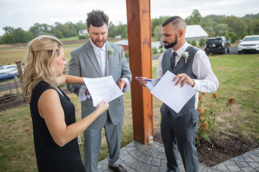 A man and woman are signing a document during their wedding ceremony.