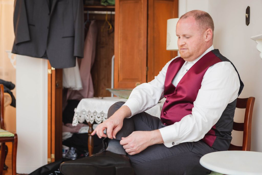 A man candidly preparing his shoes for a wedding.