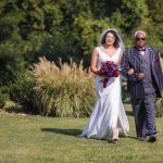A bride enters the wedding ceremony with her father.