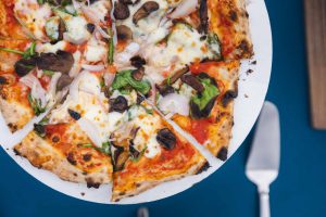 A pizza with wedding details on a plate.
