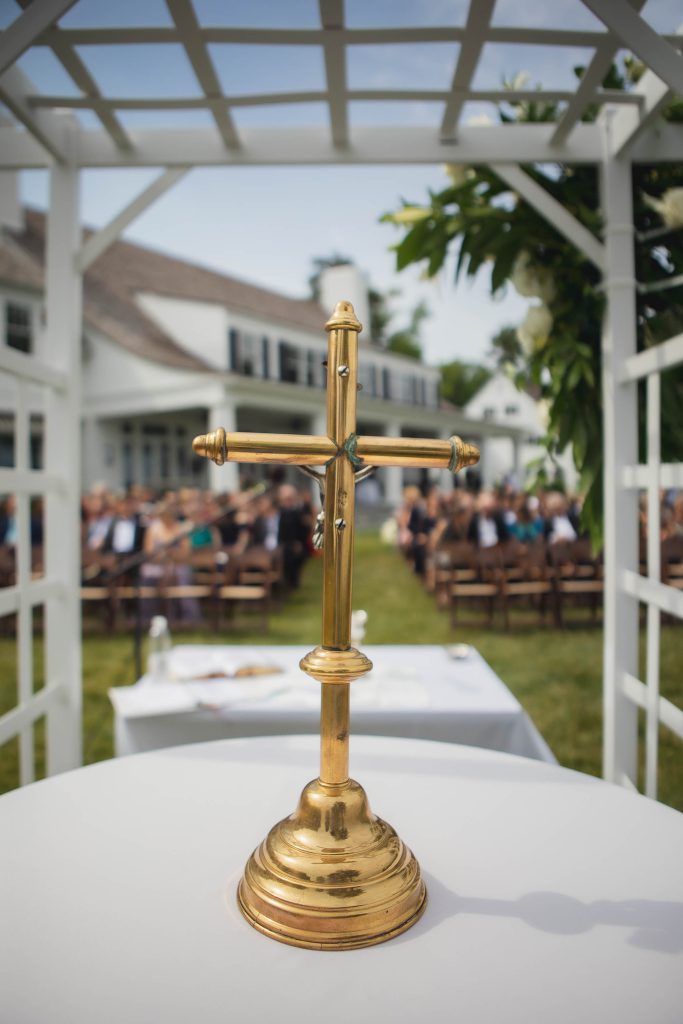 A gold wedding cross amidst a crowd.