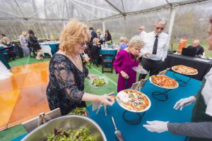 A group serving pizza at a wedding reception.