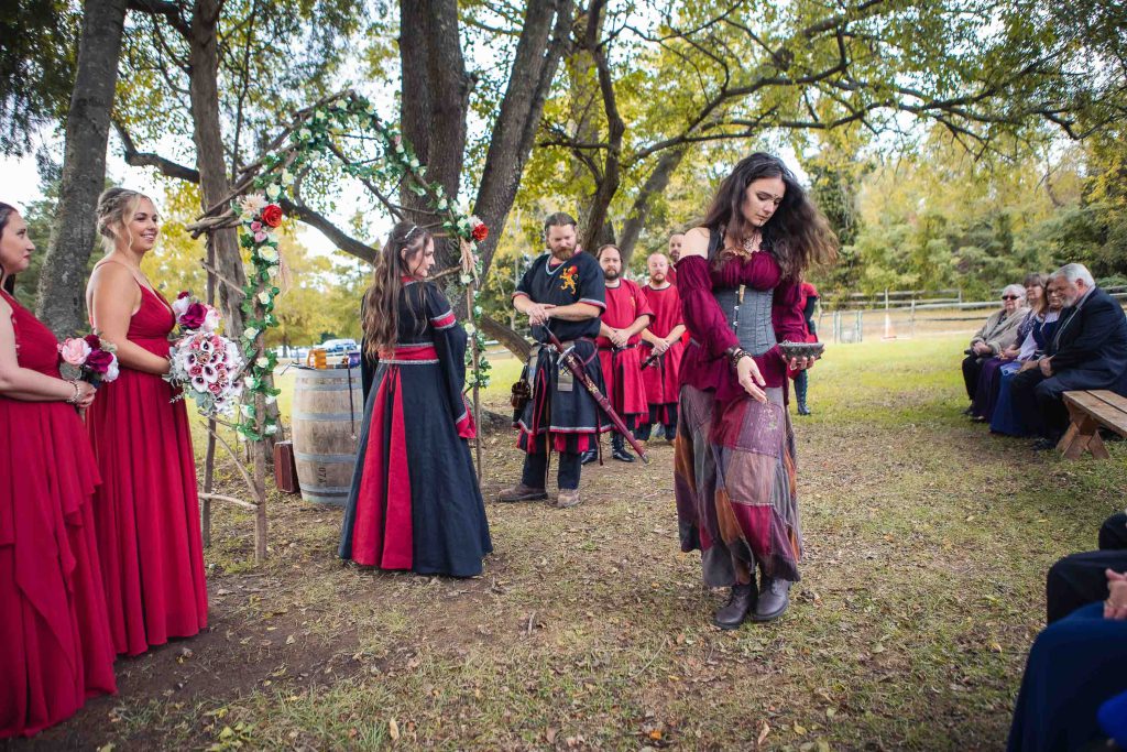 A wedding ceremony with a bride and groom in red dresses.