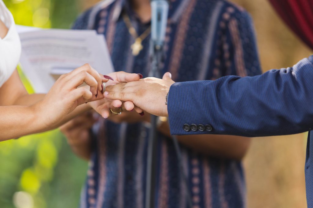 A bridal couple exchanging wedding rings during their ceremony.