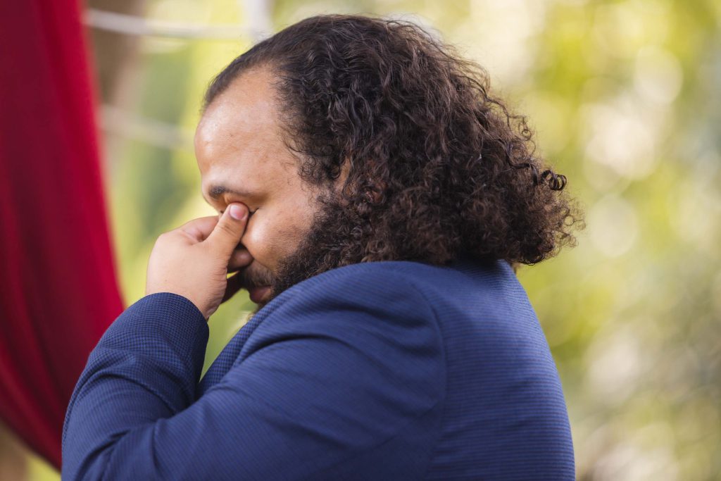 A man in a blue suit attending a wedding ceremony.