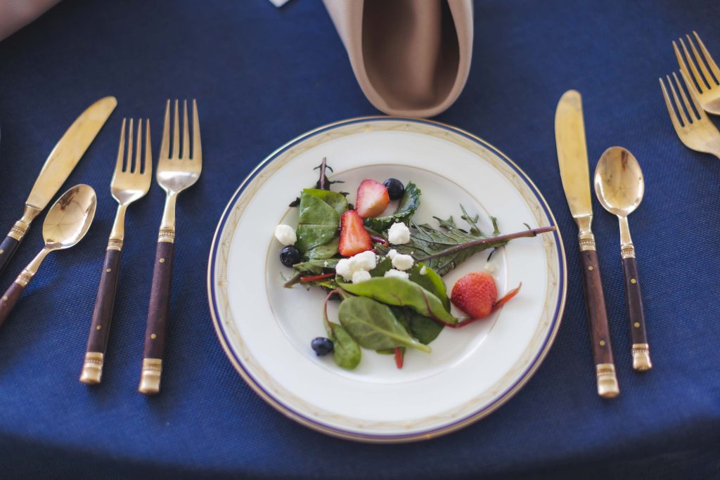 A wedding table adorned with salad and forks.