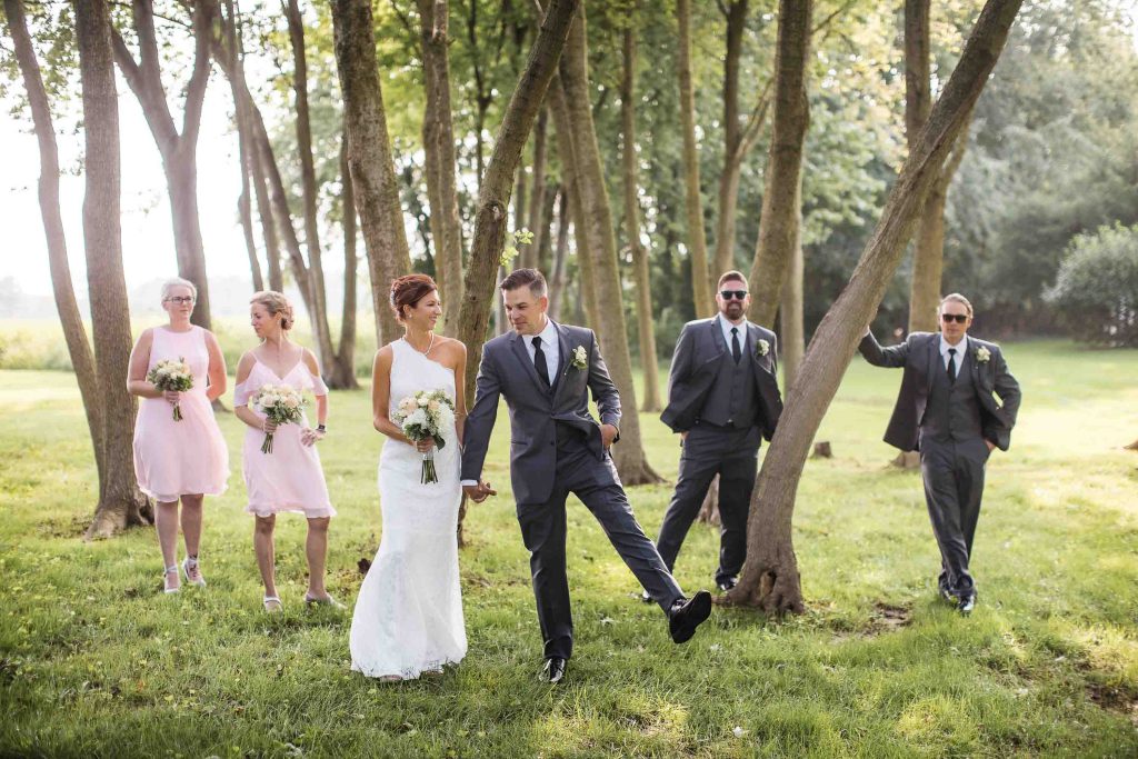 A wedding party posing for a portrait in the woods.