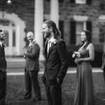 A black and white portrait of wedding groomsmen in front of a mansion.