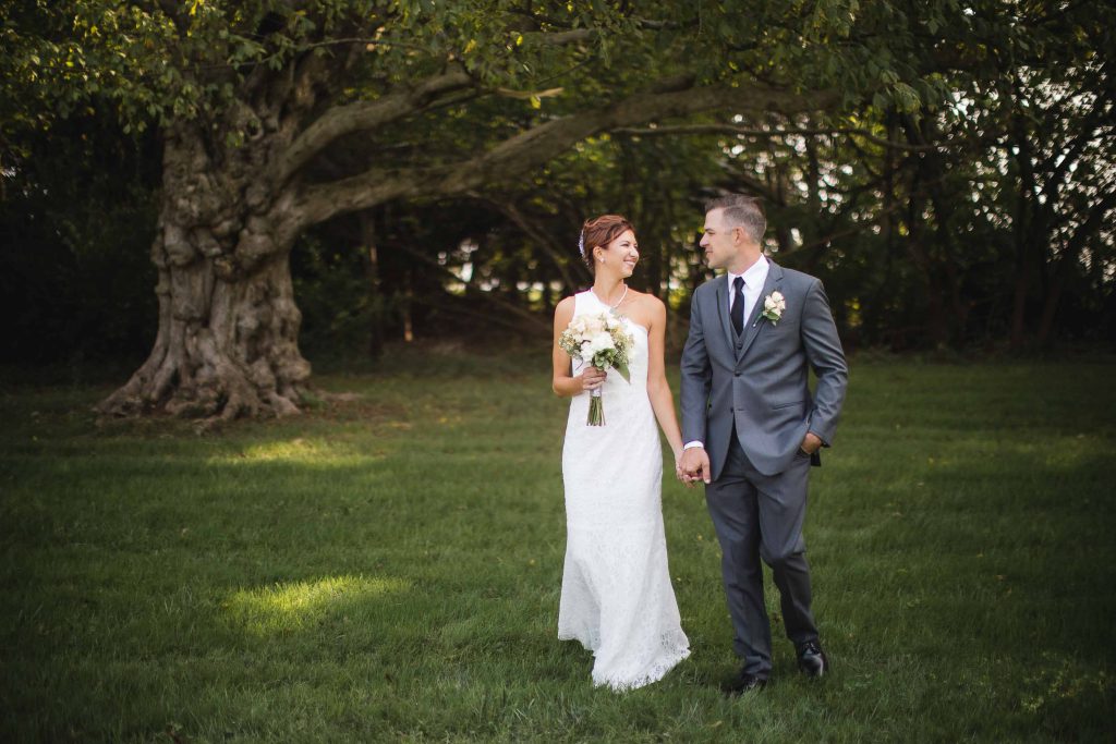 A wedding couple posing in front of a tree for a portrait.