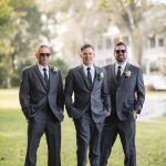 Three groomsmen posing for a wedding portrait.