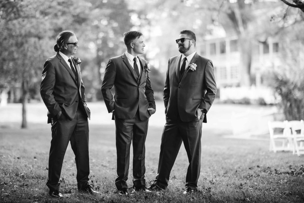 Wedding portrait of three groomsmen in suits.