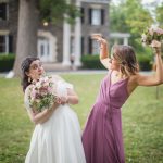 Two bridesmaids holding wedding bouquets.