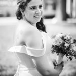 A monochrome portrait of a bride holding her bouquet on her wedding day.