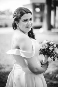 A monochrome portrait of a bride holding her bouquet on her wedding day.