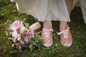 Wedding details: A bride's shoes and bouquet in the grass.