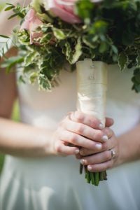 A bride holds a bouquet of roses at her wedding.