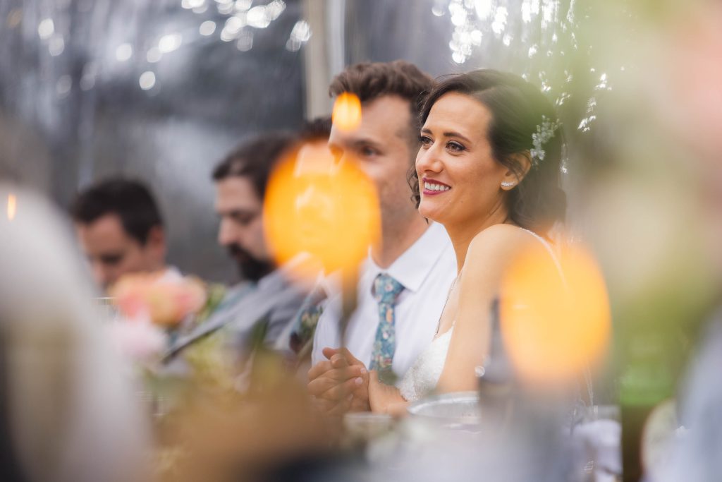 A couple smiling at each other at their wedding reception.