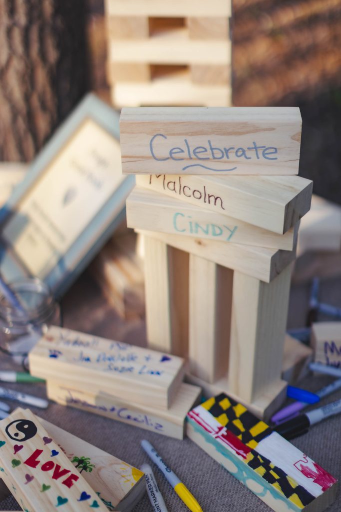 A table with wooden blocks and markers on it, showcasing wedding details.