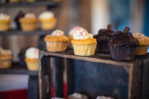 A wooden crate with cupcakes on it.