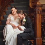 A wedding portrait of a bride and groom sitting on a staircase.