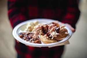 A person holding a plate with food on it at a wedding event.