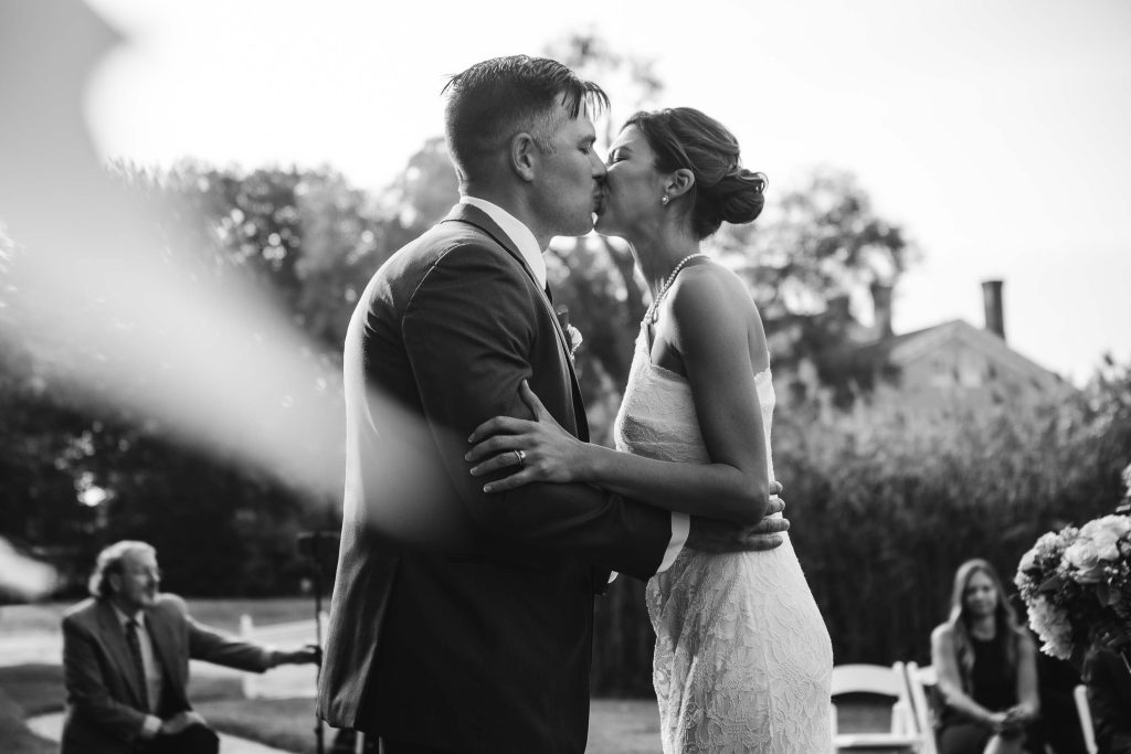 A couple kisses during their wedding ceremony.