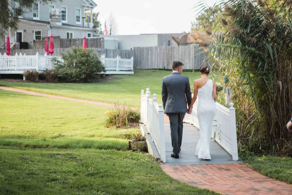 A wedding couple walking down a ceremony walkway.