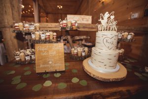A wedding cake is sitting on a table, showcasing intricate details, in a rustic barn.