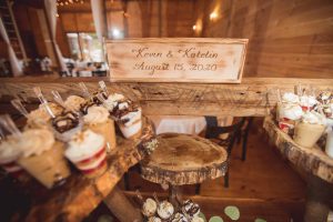 A wedding dessert table with cupcakes and a sign on it.