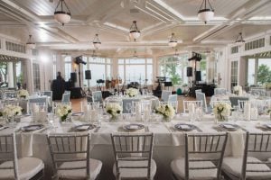 Wedding reception featuring white tables and chairs that showcase intricate details.