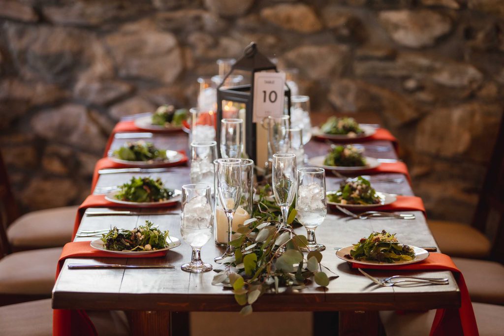 A beautifully decorated wooden table set with plates and napkins, showcasing intricate wedding details.