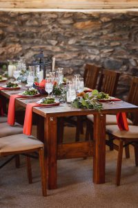 A wedding table set with red and green napkins, with intricate details.