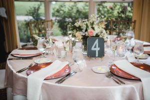A wedding table setting with pink and gold place settings.