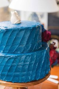 A detailed wedding cake on a wooden stand.