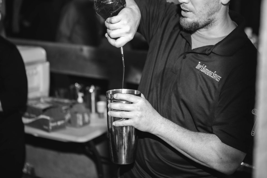 A man pouring a drink at a wedding reception.